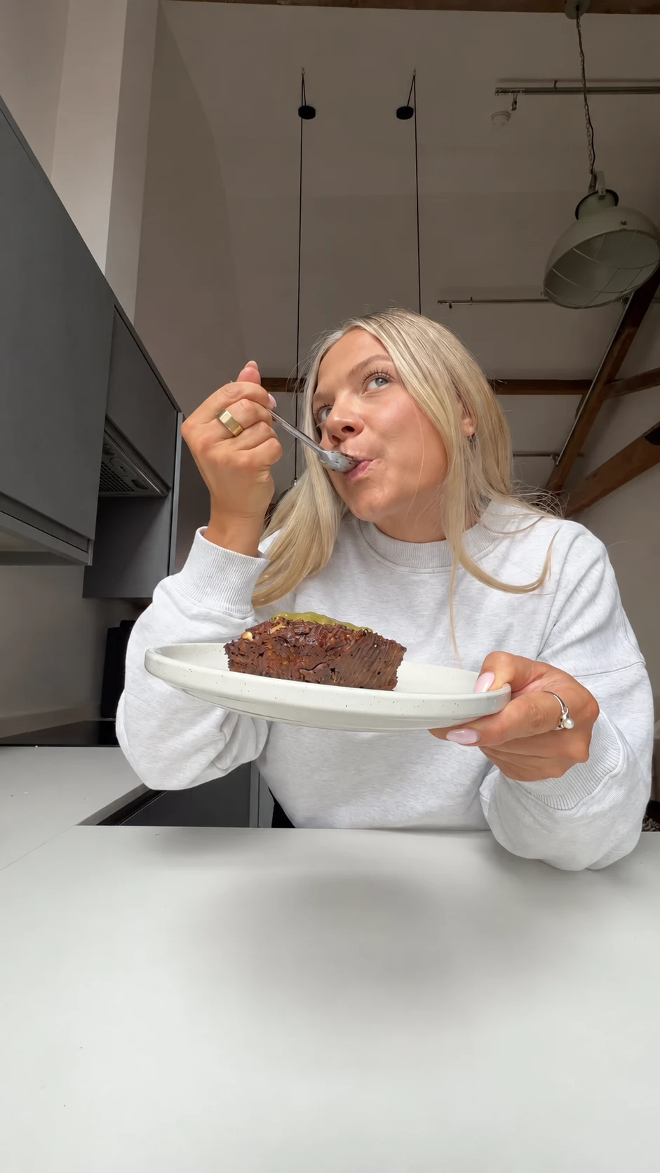 Becky enjoying pistachio and white chocolate baked oats in her kitchen